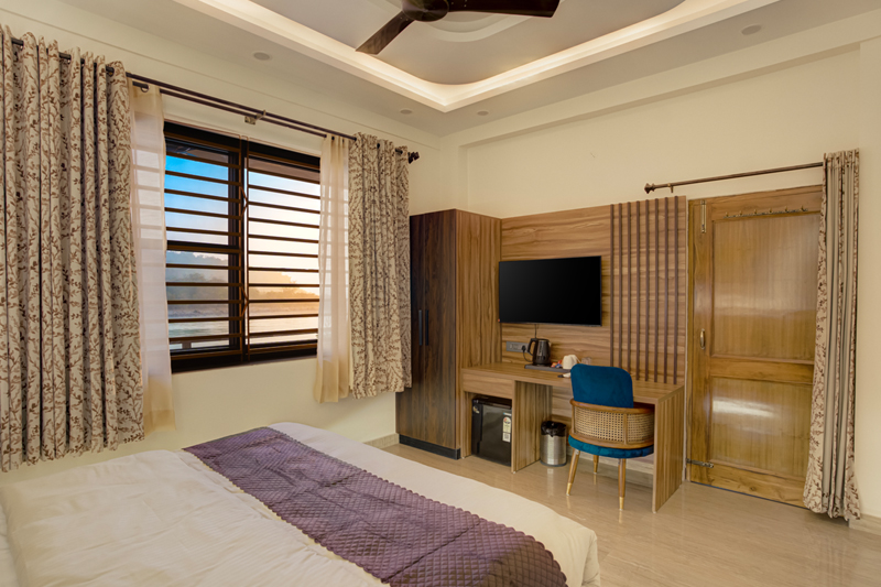 Bright hotel room interior showing smart television and writing desk setup — Sharnam on the Ganges, Rishikesh